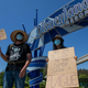 People holding signs in front of Anaheim’s Disneyland as part of a cast member unions protest against reopening without on-demand covid-19 testing.